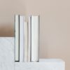 Geometric modern marble shelf with set of various books against beige background